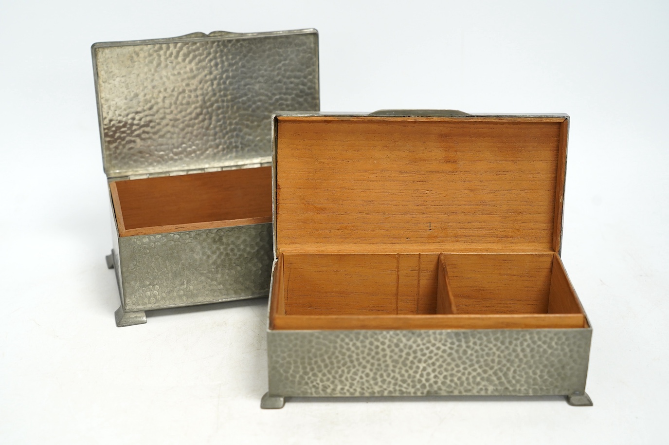 Two pewter cigarette boxes including a Liberty Tudric hammered form, largest 17.5cm wide. Condition - good